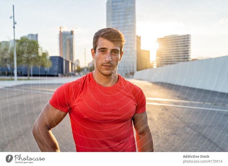 Crop muskulöser Sportler nach dem Training auf der Straße Muskel Unterleib maskulin Macho Haarschnitt Fahrbahn Himmel Mann Großstadt Gesunder Lebensstil Pause