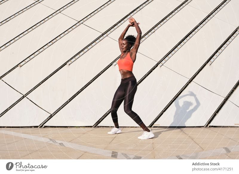 Schwarze Sportlerin auf der Straße an einem sonnigen Tag Athlet Großstadt Frau Lächeln schlank passen heiter Tanzen ethnisch schwarz Afroamerikaner