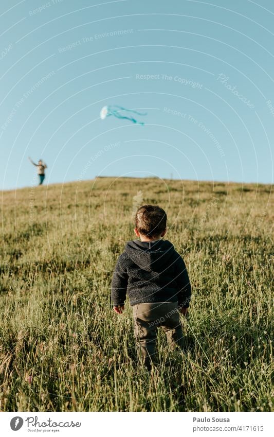 Rückansicht Kind schaut auf Kite Milan 1-3 Jahre Spielen Junge Kindheit Mensch Kleinkind Farbfoto Freude Fröhlichkeit Freizeit & Hobby Natur Leben Außenaufnahme