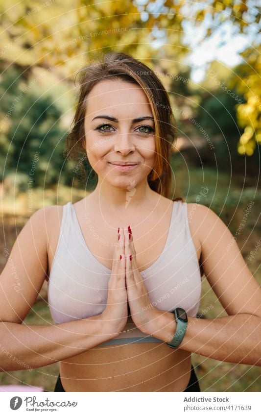 Lächelnde Frau beim Yoga im Park Namaste gestikulieren üben Achtsamkeit Gebet Hand Inhalt Zen Windstille Energie Harmonie friedlich Natur Vitalität Gesundheit