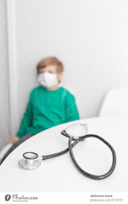 Unerkanntes Kind mit Maske im Krankenhaus Stethoskop Phonendoskop medizinisch Raum Junge Coronavirus Bund 19 Werkzeug Medizin Büro Tisch Seuche COVID19 Klinik