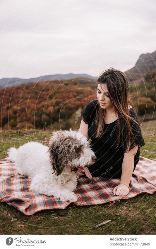 Lächelnde Frau umarmt Hund in der Natur Besitzer kuscheln Freundschaft spanischer Wasserhund Zusammensein Umarmung genießen Decke Wochenende Haustier Tier