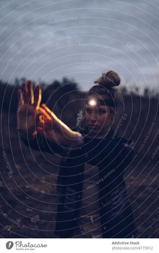 Reisender mit Stirnlampe bei der Erkundung der nächtlichen Natur Frau Scheinwerfer erkunden Wanderung dunkel Nacht Abenteuer Aktivität Tourismus jung wild Licht