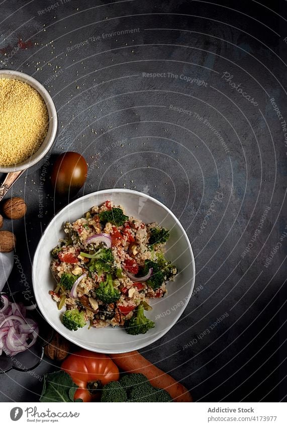 Vegetarischer Couscoussalat auf dem Tisch mit Zutaten Salatbeilage Gemüse Vegetarier bulgur tabbouleh Gesundheit Bestandteil Lebensmittel Schalen & Schüsseln