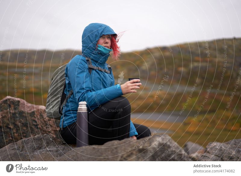 Entdeckerin trinkt Tee aus Thermoskanne im Hochland Reisender Frau Tasse Berge u. Gebirge heiß trinken Herbst trist Abenteuer Fernweh Landschaft Felsen