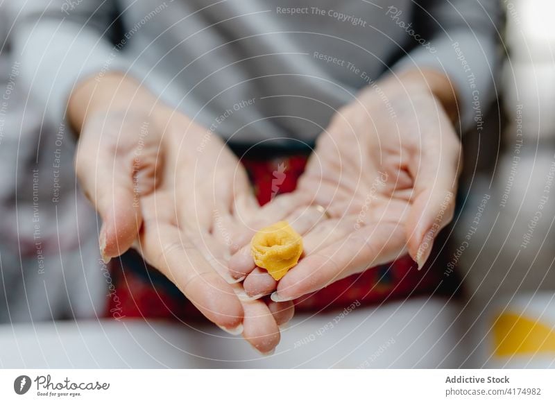 Crop Frau mit leckeren Tortellini zu Hause Italienische Küche Tradition roh Koch Knödel selbstgemacht Lebensmittel ungekocht heimwärts Hausfrau vorbereiten