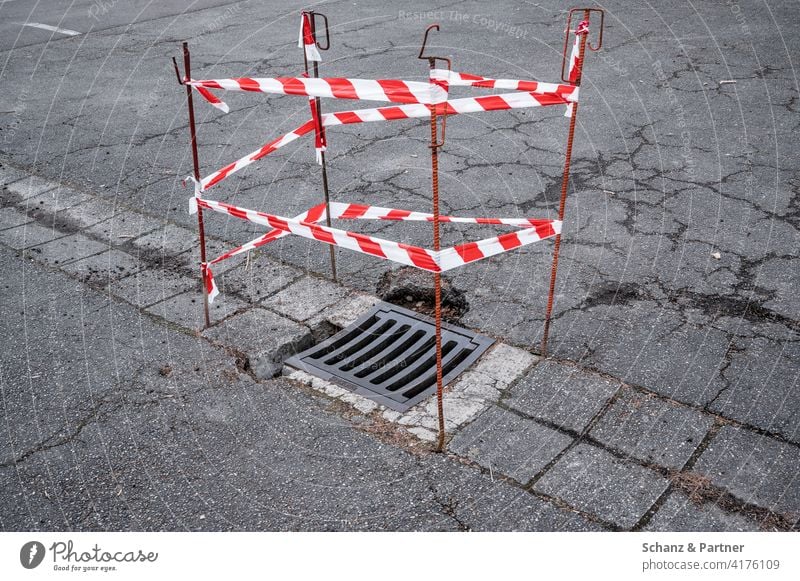 Mit Flatterband abgesperrter Gullideckel Absperrung Baustelle Rost Asphalt Straßenschäden Reparatur Straßenbau schwarze Null Schuldenbremse Investitionen