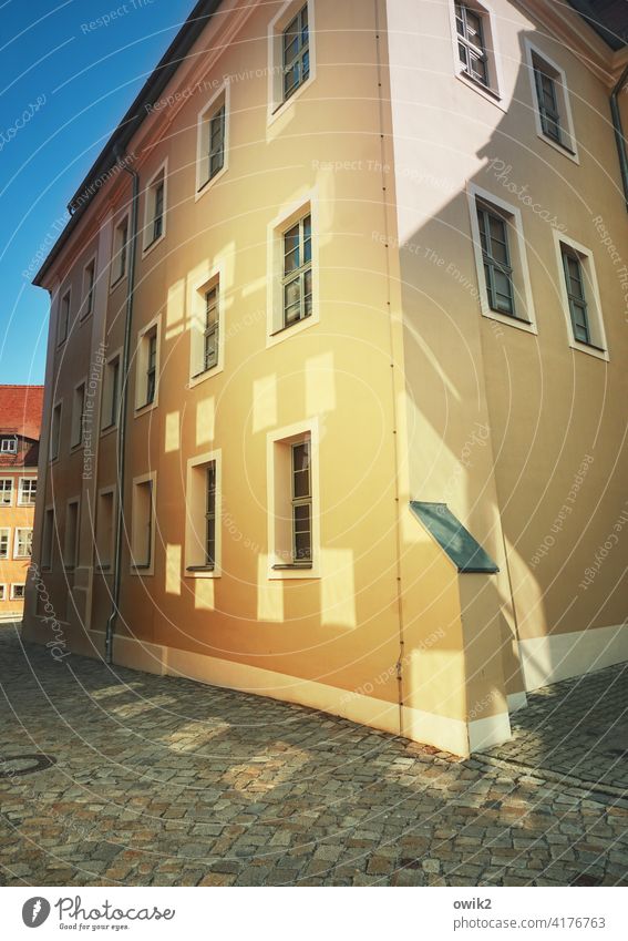 Sonniges Design Haus Hausecke Lichterscheinung Fenster leuchtend gegenüber Spiegelung Gasse schmal mittelalterlich eng wolkenloser Himmel Hauswand gelblich