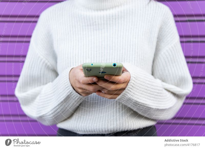 Anonyme Frau benutzt Mobiltelefon in der Nähe einer Hauswand tausendjährig Smartphone sprechen Großstadt Straße urban Wand benutzend Gerät Apparatur Handy