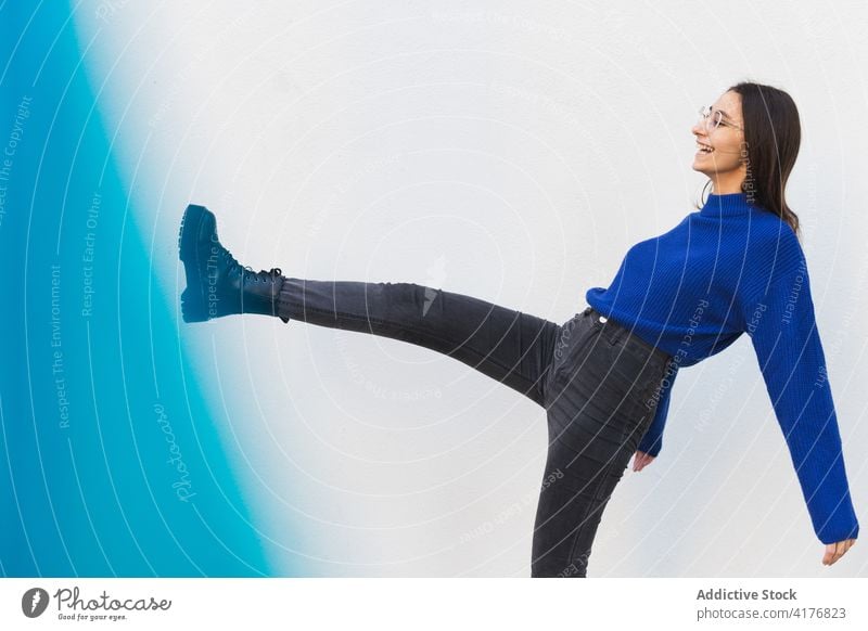 Unbekümmerte junge Frau hat Spaß in der Stadt tausendjährig Spaß haben heiter Großstadt urban cool Stil aufgeregt Licht Filter blau Outfit Straße Lächeln froh