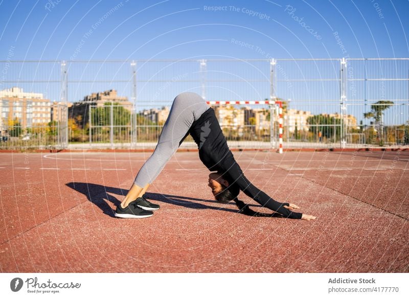 Frau macht nach unten gerichteten Hund während Yoga-Übungen Training adho mukha svanasana nach unten gerichteter Hund üben Gleichgewicht beweglich akrobatisch