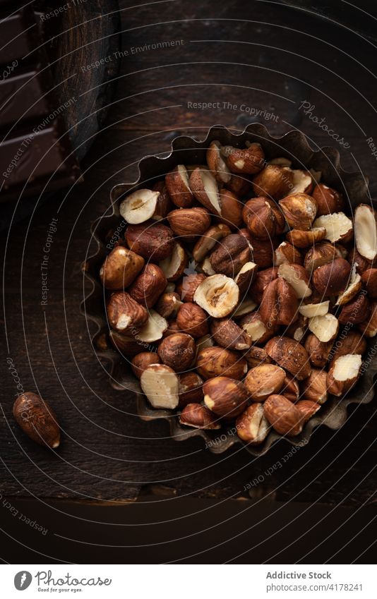 Haufen Haselnüsse in Metallschüssel auf Tisch Haselnuss Nut Schalen & Schüsseln rustikal Ernährung Küche dunkel gesunde Ernährung Geschirr Küchengeräte