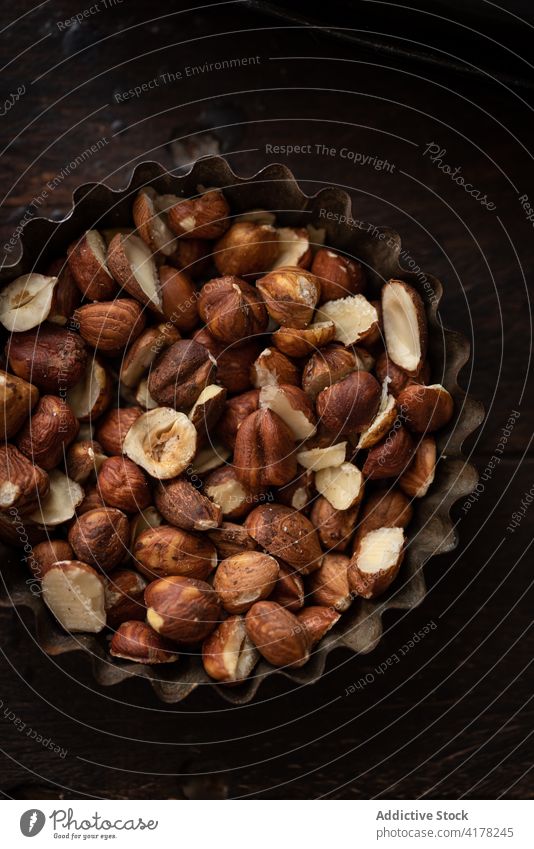 Haufen Haselnüsse in Metallschüssel auf Tisch Haselnuss Nut Schalen & Schüsseln rustikal Ernährung Küche dunkel gesunde Ernährung Geschirr Küchengeräte