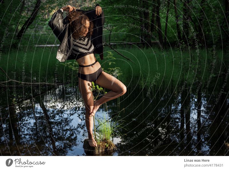 Eine wunderschöne Frau übt ihre Tanzschritte inmitten eines schlammigen Sumpfes. Wildes Mädchen in wilder Natur. Die Sommerabenteuer fangen gerade erst an.