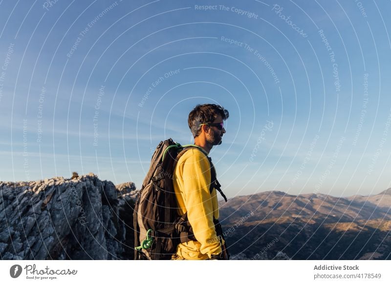 Reisender Mann steht auf felsigen Gipfel bei Sonnenuntergang Berge u. Gebirge Felsen Freiheit einsam Entdecker rau Abenteuer Rucksack Top Natur männlich Fernweh