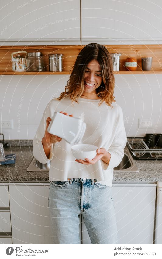 Positive Frau macht Frühstück am Morgen gesunde Ernährung Diät Gesundheit eingießen Küche Schalen & Schüsseln heiter hinzufügen Lebensmittel frisch