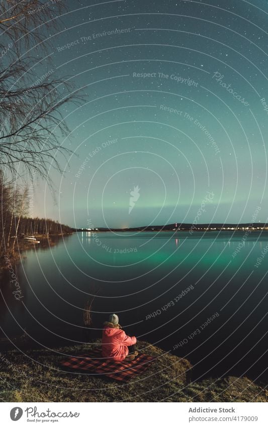 Reisende genießen die Aussicht auf Polarlichter über dem See nördlich Licht Reisender Aurora Nordlicht bewundern Nacht Winter Himmel erkunden Ufer Entdecker