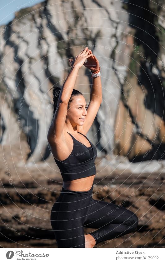 Lächelnde Frau, die in Baumhaltung steht und Yoga macht vrksasana üben Gleichgewicht Asana Natur Berge u. Gebirge Sportbekleidung Vitalität Wohlbefinden