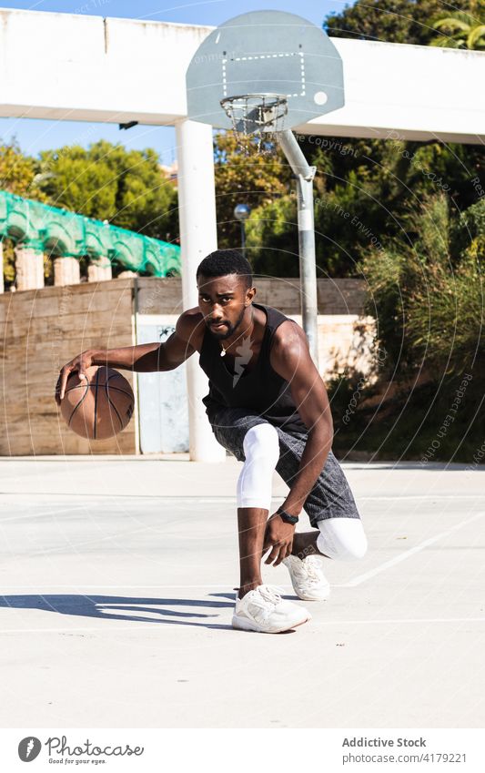 Schwarzer Mann spielt Basketball auf Sportplatz spielen Sportpark Spieler Sportler aktiv Ball Sommer männlich ethnisch schwarz Afroamerikaner Athlet üben