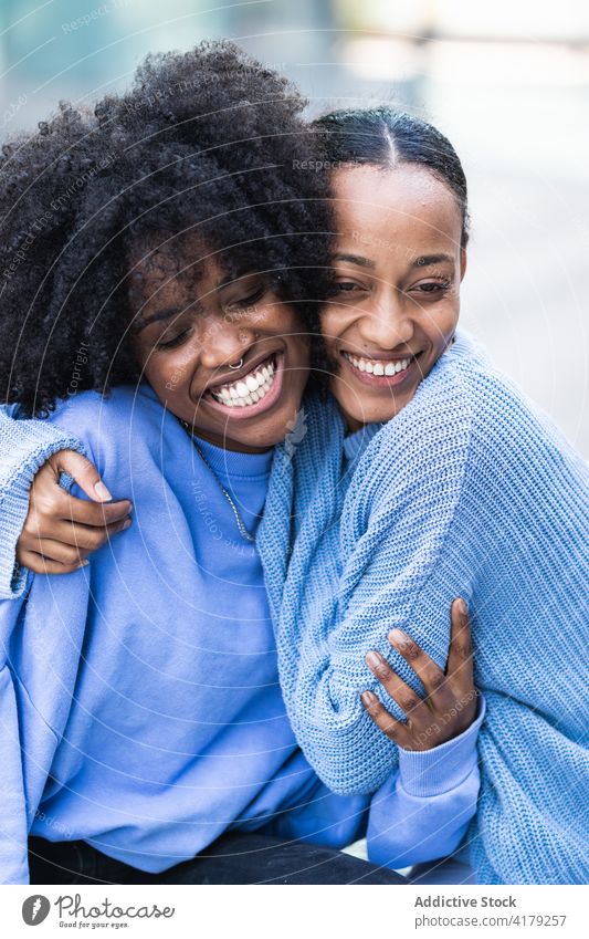 Entzückte schwarze Freundinnen ruhen sich auf einer Bank aus heiter Zusammensein Glück kuscheln ähnlich genießen bester Freund jung Frauen Afroamerikaner