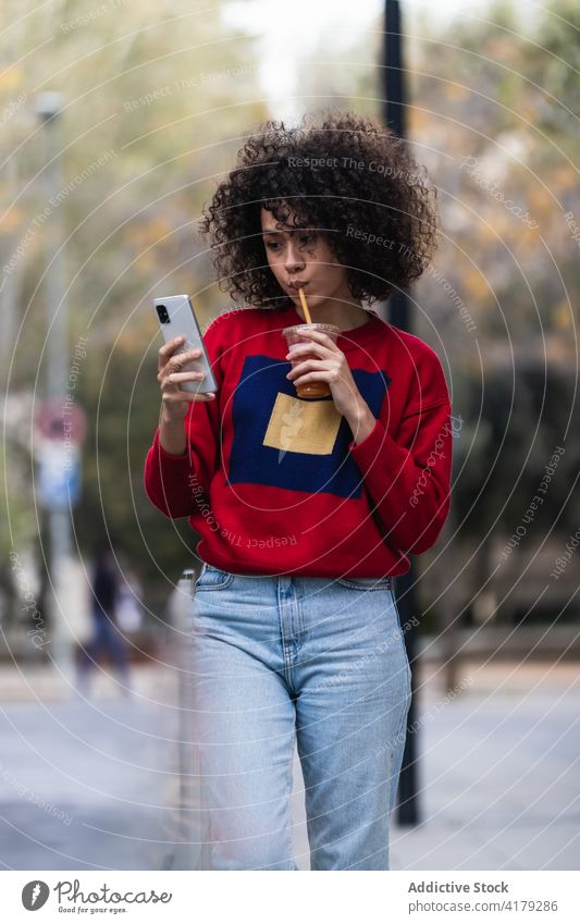 Schwarze Frau nimmt Selfie mit Becher Saft zum Mitnehmen Imbissbude Smartphone fotografieren Selbstportrait soziale Netzwerke Großstadt genießen ethnisch