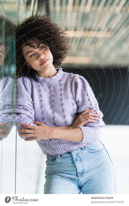 Verträumte schwarze Frau lehnt an einem Gebäude auf der Straße nachdenklich verträumt Großstadt Denken nachdenken krause Haare Afro-Look ethnisch Afroamerikaner