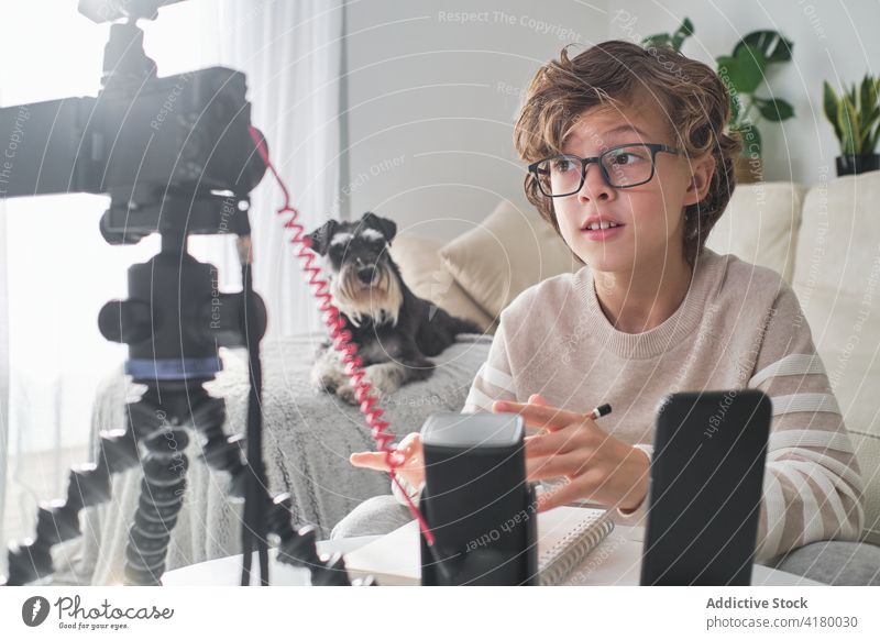 Happy Boy nimmt sich selbst auf zu Hause Kind Junge kleiner Junge youtuber Vorderansicht Liege vorbereitend Technik & Technologie Gerät Telefon Funktelefon