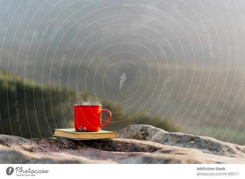 Eine Tasse Heißgetränk und ein Buch in den Bergen trinken Berge u. Gebirge gemütlich Atmosphäre Hochland heiß Metall Becher Lautstärke Felsen Gelände Getränk