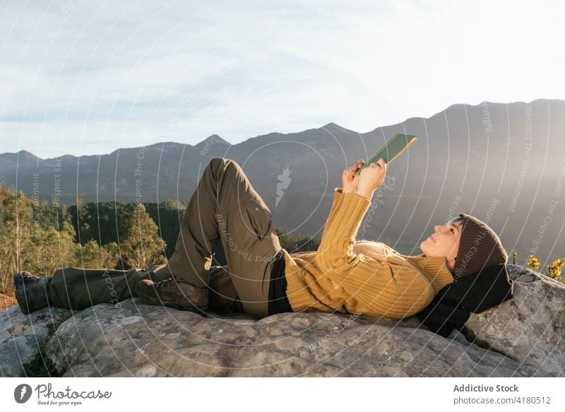 Reisende Frau, die in den Bergen ein Buch liest reisen lesen Berge u. Gebirge trinken Getränk Hochland genießen Harmonie Reisender Lügen Tasse heiß interessant