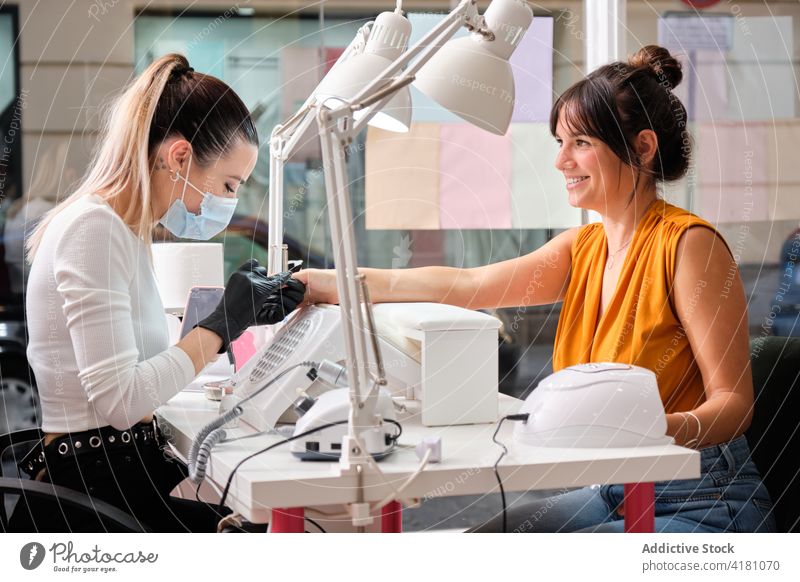 Glückliche Frau bei der Maniküre im Schönheitssalon Klient Meister professionell Salon Dienst Verfahren Leckerbissen heiter Arbeit Werkzeug Spezialist Lifestyle