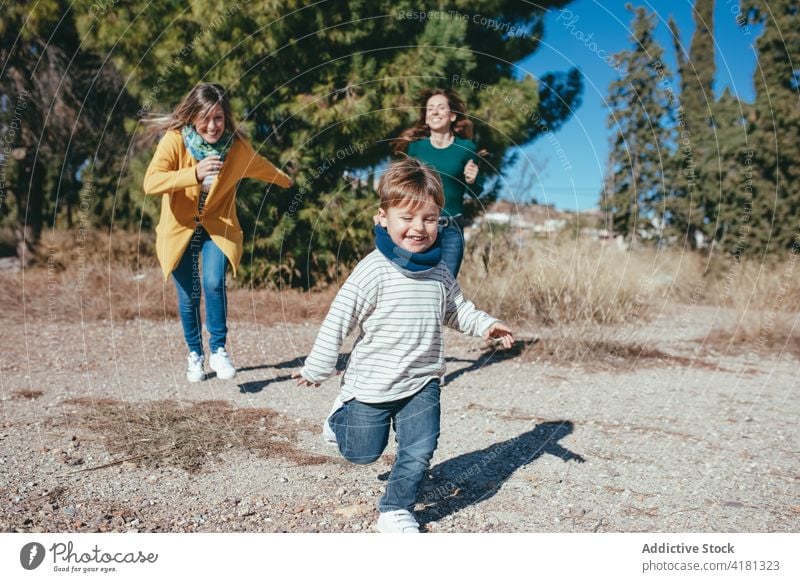 Fröhliches lesbisches Paar läuft mit Sohn im Park Familie Freude lgbt heiter laufen Natur Homosexualität lgbtq bezaubernd Partnerschaft Liebe Glück Eltern