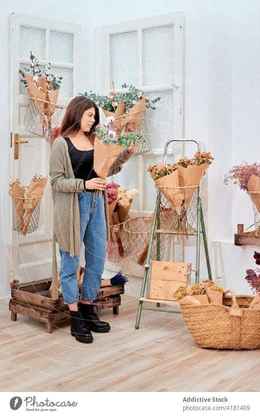 Frau wählt Blumen im Blumenladen aus Klient Blumenstrauß Floristik Papier Paket Wahl kaufen Blütezeit Laden Kunde Haufen Mitarbeiter natürlich Kleinunternehmen