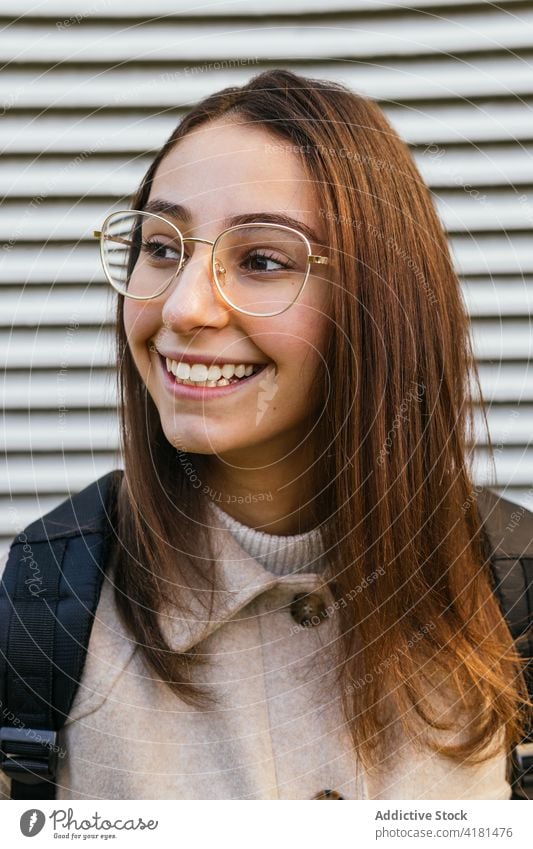 Crop lächelnde Studentin mit Rucksack auf der Straße Frau Zahnfarbenes Lächeln Schüler positiv Optimist froh Glück heiter Inhalt stehen hübsch charmant