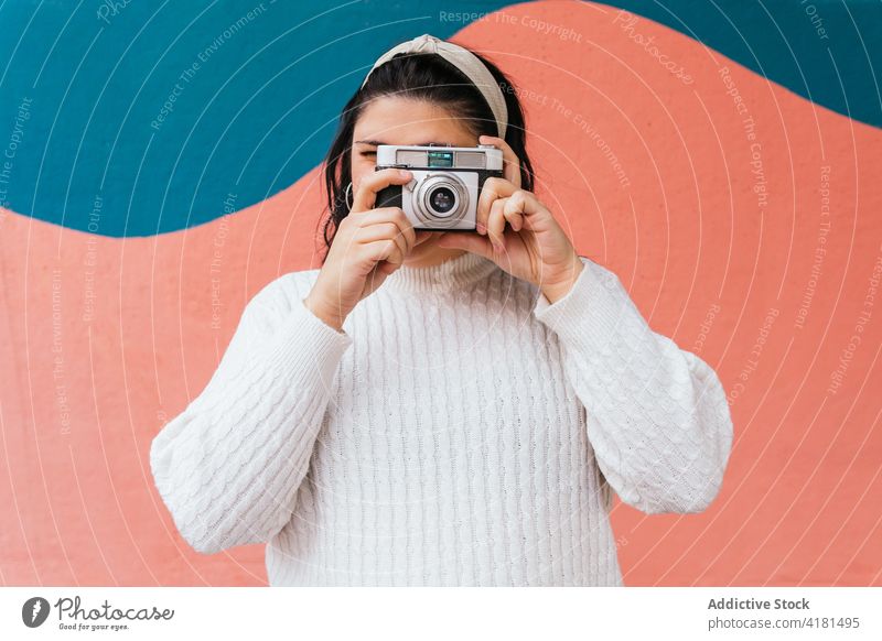 Unbekannter Fotograf fotografiert mit Kamera in der Nähe einer Mauer im Freien fotografieren Fotoapparat digital Fokus Linse Gedächtnis Frau Moment benutzend