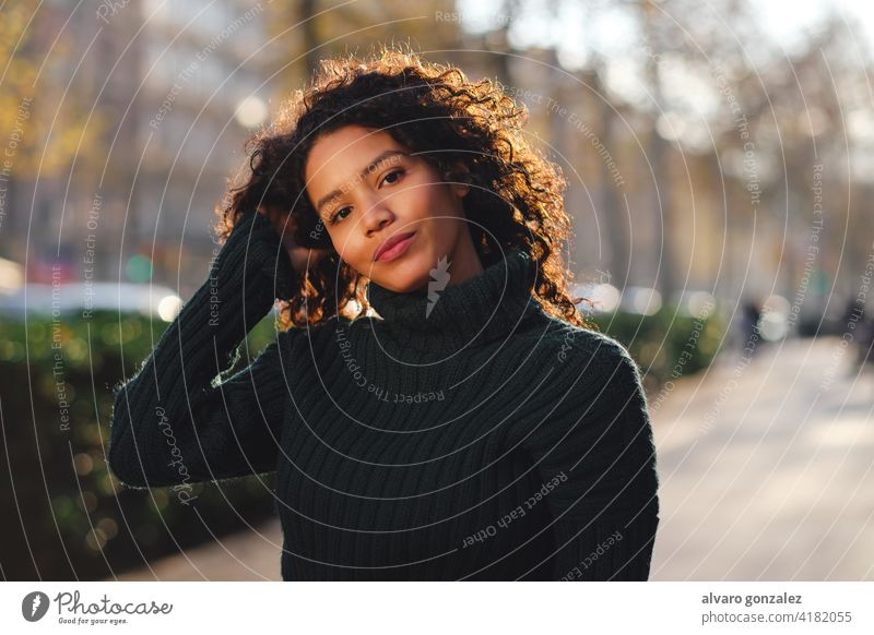 Junge Frau steht im Freien auf der Straße. jung urban Sombrero Stehen Stil Großstadt Nahaufnahme lockig Behaarung Frisur warm Bekleidung trendy eine posierend