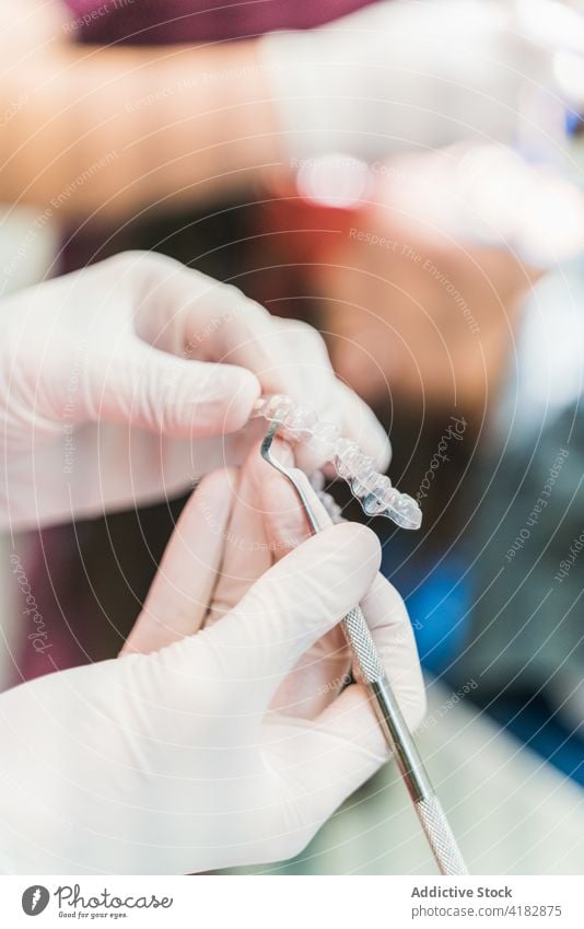 Gesichtsloser Zahnarzt in Handschuhen mit Veneers und Zahnsteinentferner Furnier Scaler Stomatologie dental Klinik Arbeit Werkzeug Praktiker Person Uniform