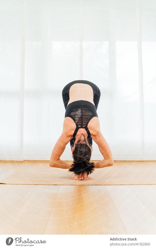 Frau in der Vorwärtsbeuge in der Yogastellung Padangusthasana große Zehe meditieren Asana positionieren Dehnung mental beweglich Körperpflege Achtsamkeit