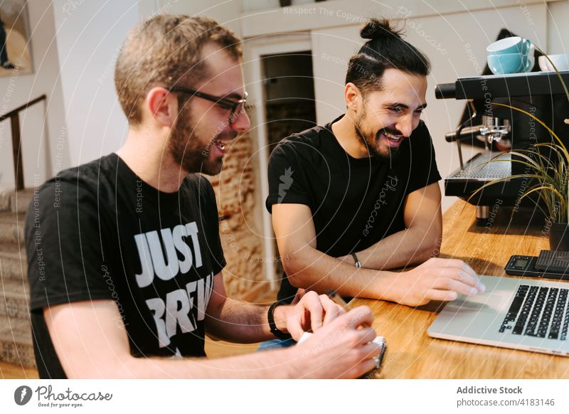 Baristas diskutieren über Arbeitsfragen im Café Männer Zusammensein Kommunizieren reden Job Laptop männlich Abfertigungsschalter Business Gespräch professionell