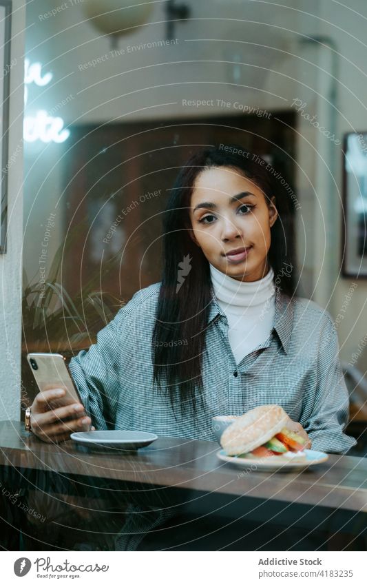 Frau trinkt eine Tasse Kaffee und benutzt ein Handy Funktelefon Technik & Technologie Telefon Mobile Kaffeehaus Glück Internet Café Drahtlos Menschen Person