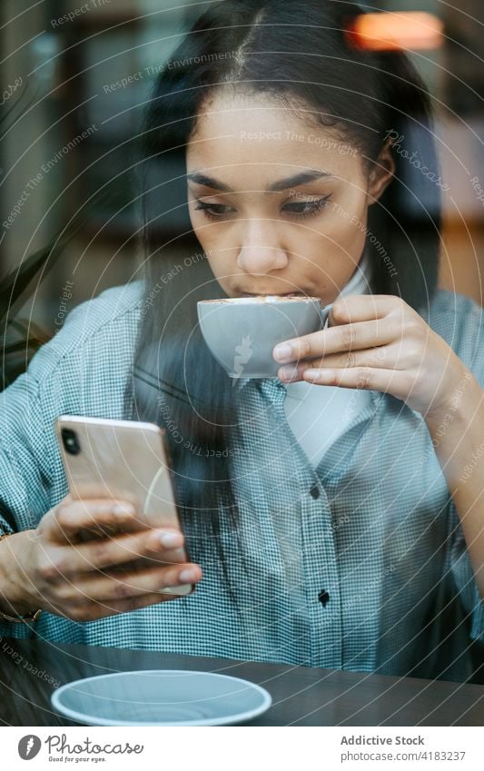 Frau trinkt eine Tasse Kaffee und benutzt ein Handy Funktelefon Technik & Technologie Telefon Mobile Kaffeehaus Glück Internet Café Drahtlos Menschen Person