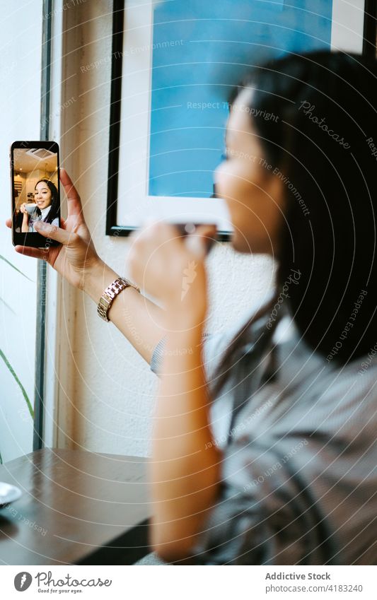 Frau trinkt eine Tasse Kaffee und benutzt ein Handy Funktelefon Technik & Technologie Telefon Mobile Kaffeehaus Glück Internet Café Drahtlos Menschen Person