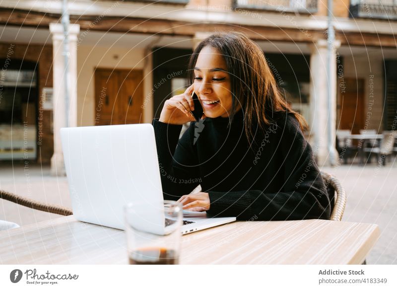 Moderne Frau mit Laptop am Tisch auf der Straße freiberuflich Café Bürgersteig Netbook Surfen Zeitgenosse abgelegen Computer Anschluss Tippen online Beruf