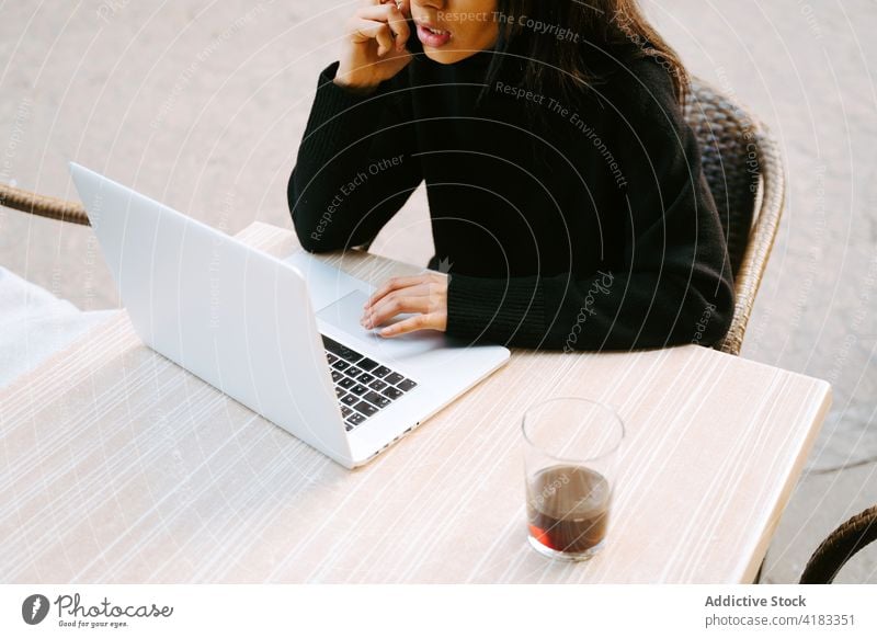 Moderne Frau mit Laptop am Tisch auf der Straße freiberuflich Café Bürgersteig Netbook Surfen Zeitgenosse abgelegen Computer Anschluss Tippen online Beruf