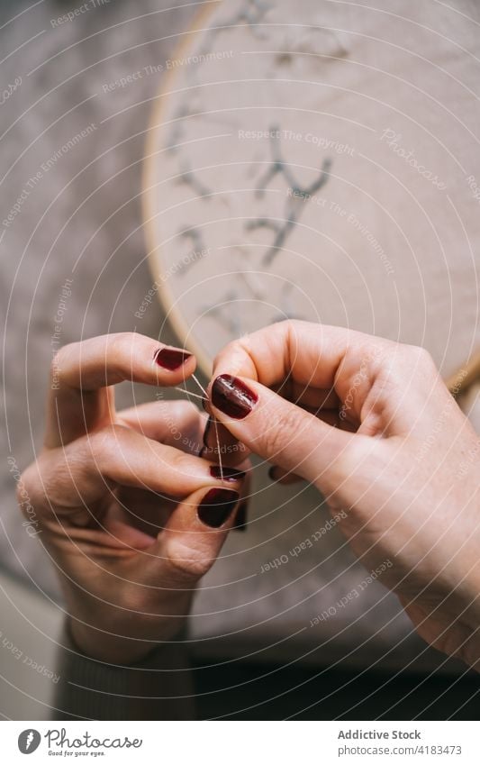 Gesichtslose Frau, die zu Hause mit einem Stickrahmen stickt Stickereien Reifen handgefertigt Faser Fähigkeit Hobby Handarbeit sticken diy Prozess Werkstatt