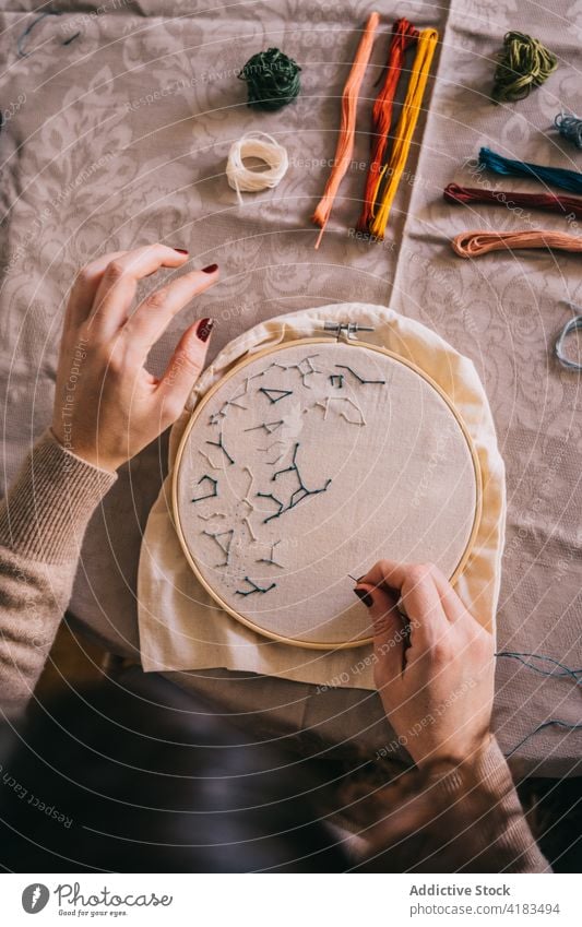 Gesichtslose Frau, die zu Hause mit einem Stickrahmen stickt Stickereien Reifen handgefertigt Faser Fähigkeit Hobby Handarbeit sticken diy Prozess Werkstatt