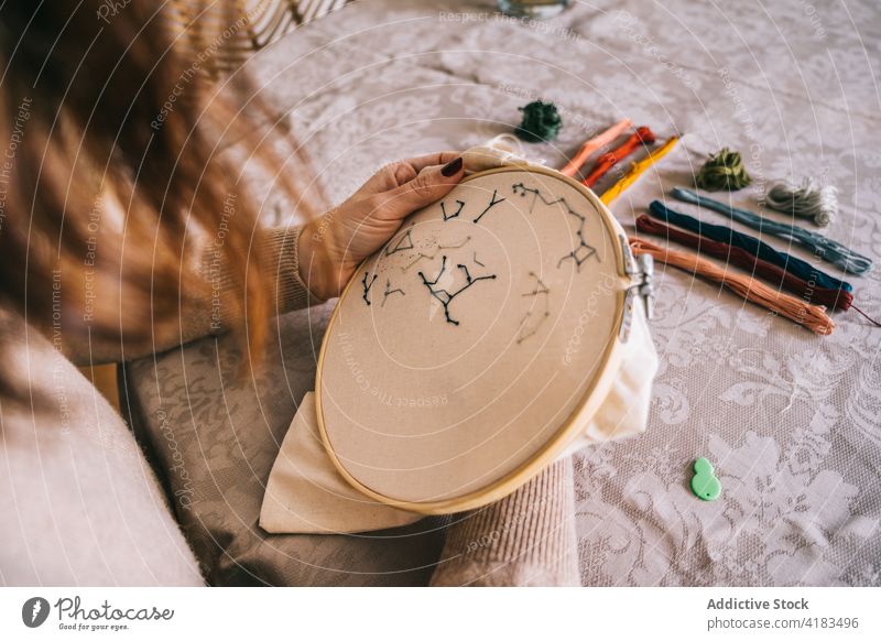 Gesichtslose Frau, die zu Hause mit einem Stickrahmen stickt Stickereien Reifen handgefertigt Faser Fähigkeit Hobby Handarbeit sticken diy Prozess Werkstatt