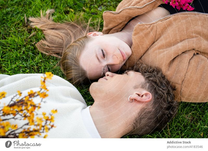 Pärchen mit blühenden Blumen auf einer Wiese liegend Paar sich[Akk] entspannen Rasen Partnerschaft Liebe sanft Zeit verbringen Sommer idyllisch ruhen freie Zeit