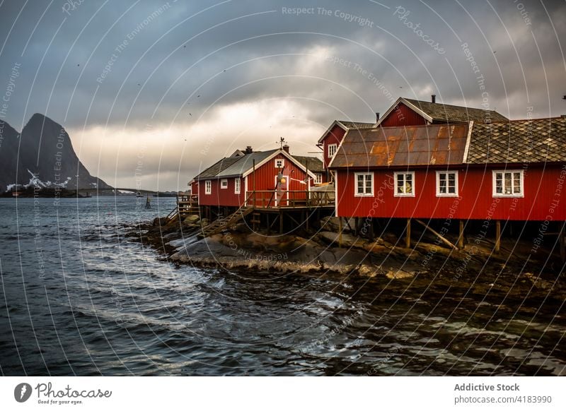 Holzhäuser in einem Fischerdorf am Meer Fischen Dorf Haus MEER wohnbedingt hölzern wolkig Himmel Meeresufer Gebäude Norwegen Berge u. Gebirge Wohnsiedlung