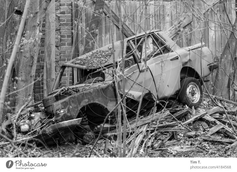 ein kaputter Wartburg liegt vor einer Einfahrt Dorf Unfall Auto car bnw PKW Verkehrsunfall Totalschaden Schrott Außenaufnahme Schaden Menschenleer Fahrzeug