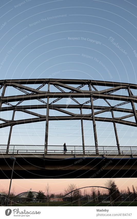 Einsammer Passasnt zur Blauen Srunde auf der Deutschherrnbrücke am Hafenpark im Ostend von Frankfurt am Main in Hessen Honsellbrücke Osthafenbrücke Blaue Stunde